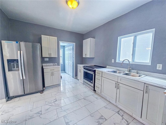 kitchen with sink, stainless steel appliances, and white cabinetry