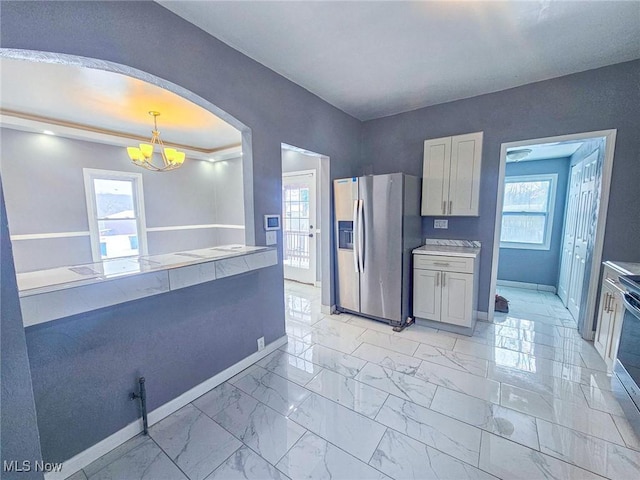 kitchen featuring decorative light fixtures, white cabinetry, stainless steel fridge with ice dispenser, and a chandelier