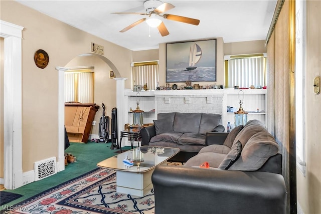 carpeted living room featuring ceiling fan and a fireplace