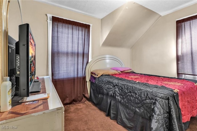 carpeted bedroom with a textured ceiling and lofted ceiling