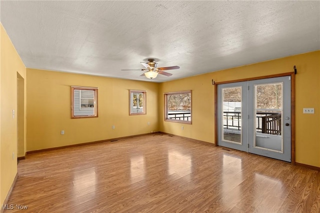 unfurnished room with a textured ceiling, ceiling fan, and light hardwood / wood-style floors