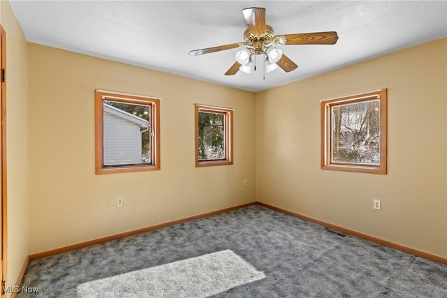 carpeted spare room with ceiling fan