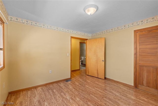 unfurnished bedroom featuring light hardwood / wood-style floors and a closet