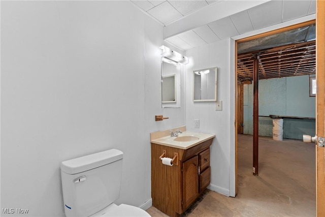 bathroom with toilet, vanity, and concrete floors