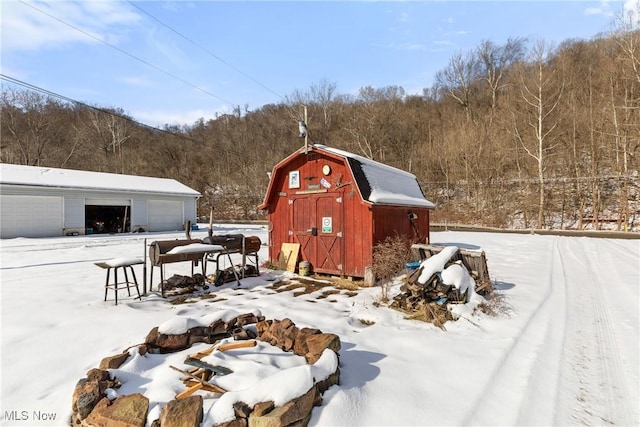 snow covered structure with a garage