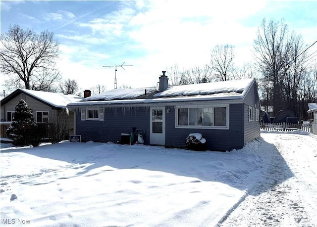 view of snow covered back of property