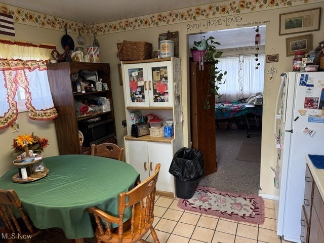 dining room featuring light carpet and light tile patterned floors