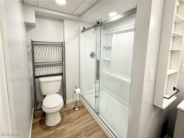 bathroom featuring vanity, a paneled ceiling, toilet, and walk in shower