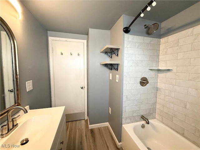 bathroom featuring tiled shower / bath combo, wood-type flooring, and vanity