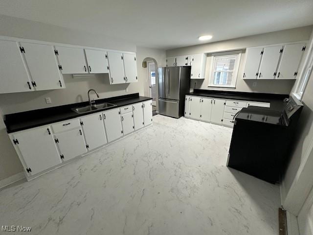 kitchen featuring white cabinetry, stainless steel fridge, and sink