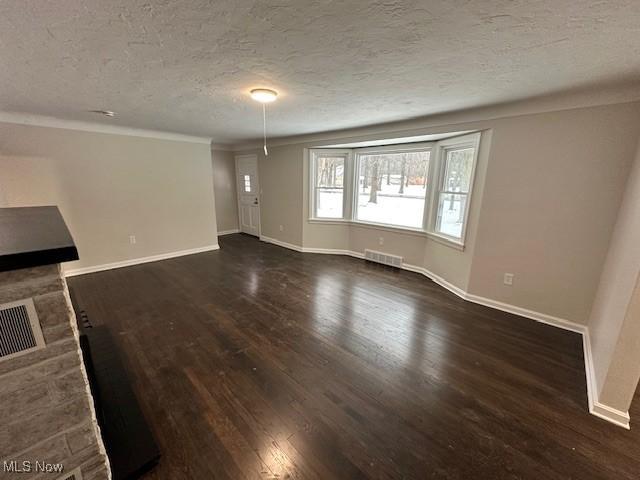 unfurnished living room with dark hardwood / wood-style floors and a textured ceiling