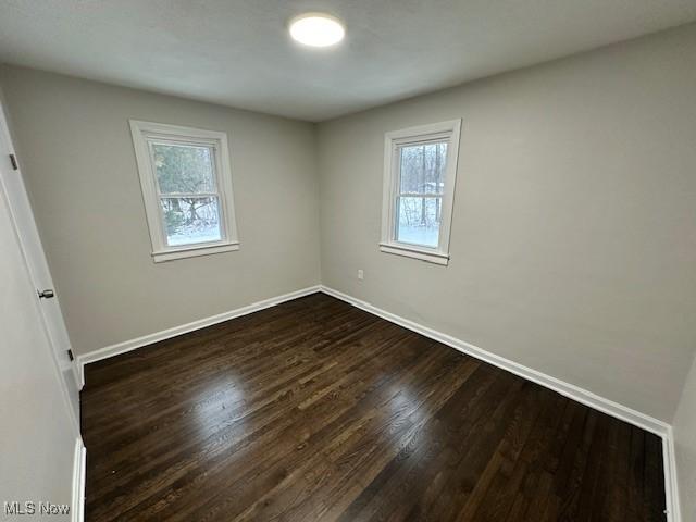 unfurnished room featuring dark hardwood / wood-style flooring