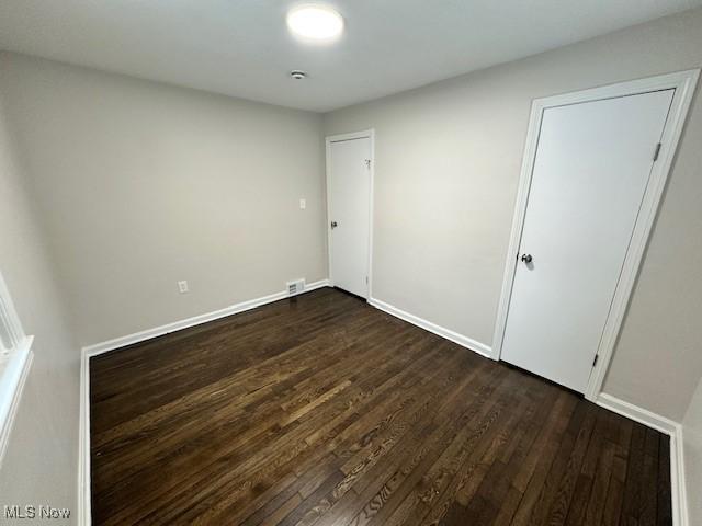 spare room with dark hardwood / wood-style flooring