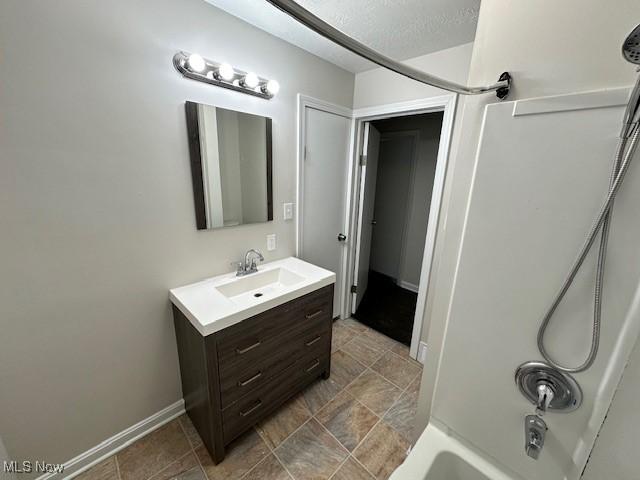 bathroom with shower / bathtub combination, a textured ceiling, and vanity