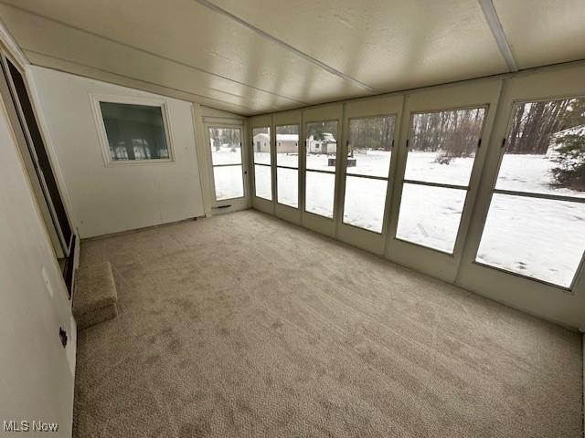 unfurnished sunroom featuring lofted ceiling