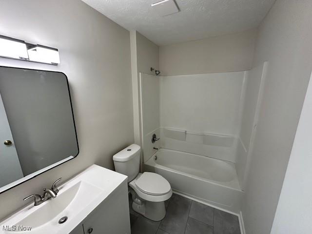 full bathroom with a textured ceiling, tile patterned floors, vanity, shower / bath combination, and toilet