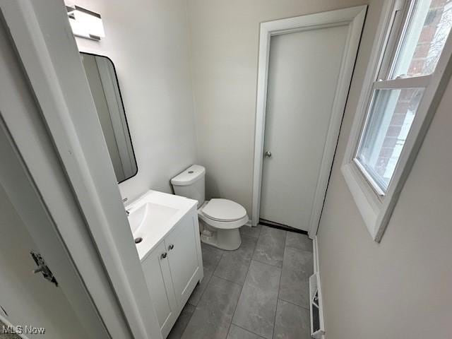 bathroom with toilet, vanity, tile patterned floors, and a healthy amount of sunlight