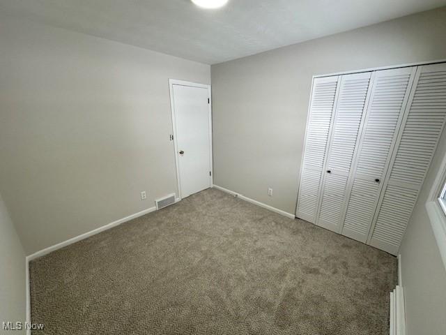 unfurnished bedroom featuring carpet floors and a closet