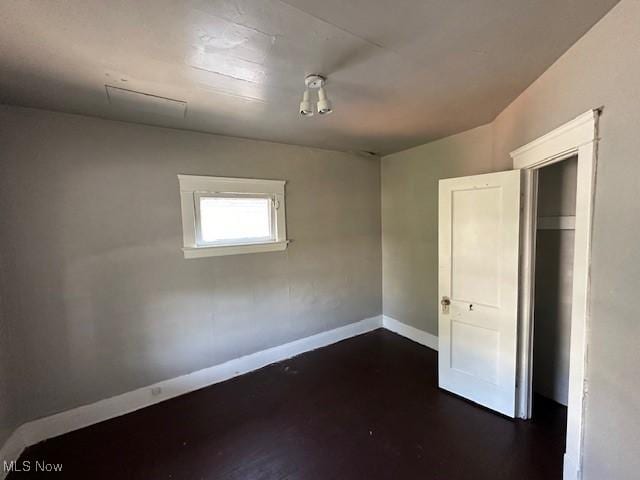 unfurnished bedroom with dark wood-type flooring