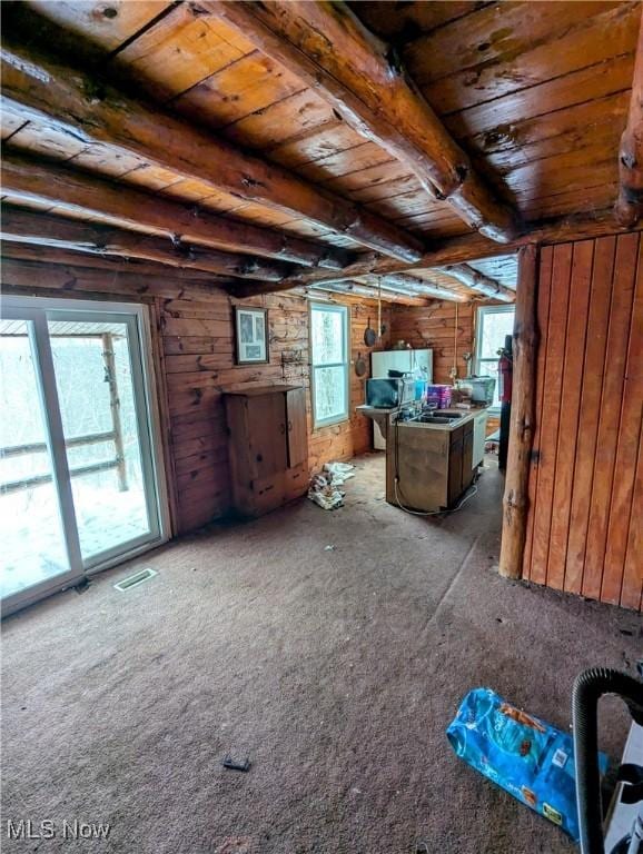 interior space with wooden ceiling, beam ceiling, and wooden walls