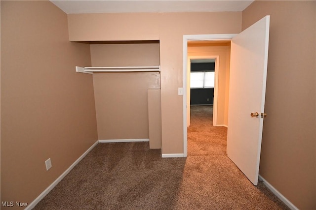 unfurnished bedroom featuring carpet and a closet