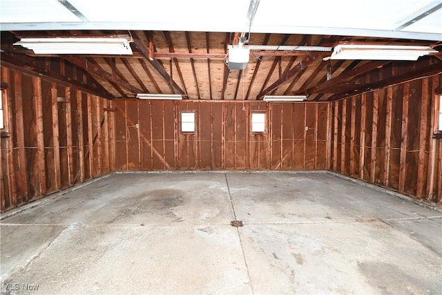 garage with a garage door opener and wooden walls