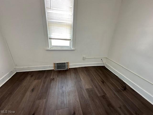 unfurnished room featuring dark hardwood / wood-style flooring