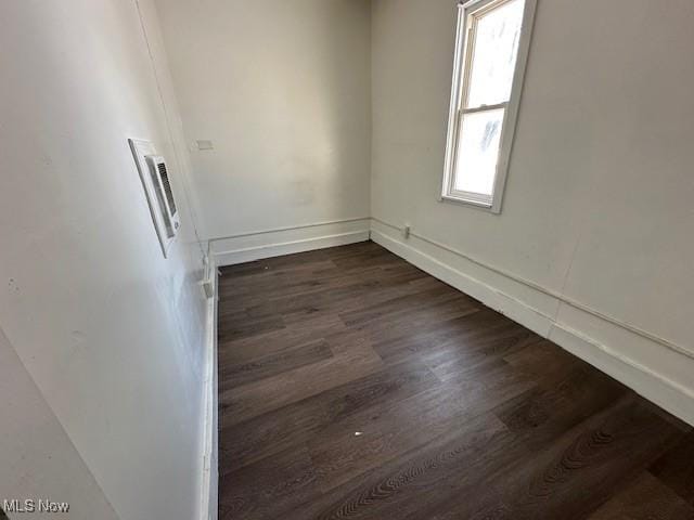 spare room with dark wood-type flooring