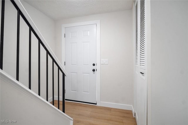 foyer with light hardwood / wood-style floors and a textured ceiling