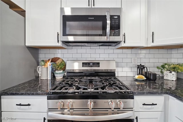 kitchen with decorative backsplash, white cabinets, appliances with stainless steel finishes, and dark stone countertops