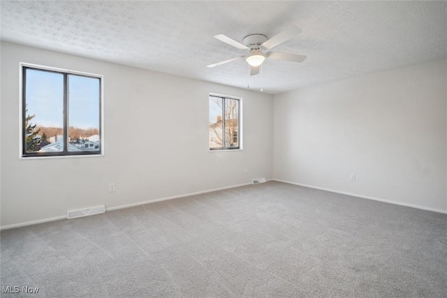 unfurnished room featuring carpet, ceiling fan, and plenty of natural light