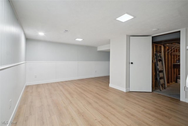 basement with light hardwood / wood-style flooring