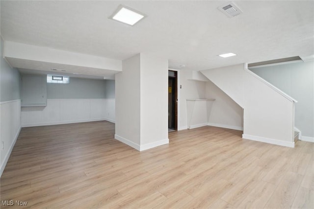 basement with light hardwood / wood-style flooring