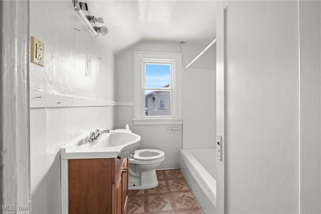 bathroom featuring toilet, lofted ceiling, and vanity