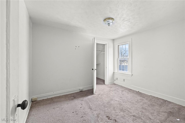 carpeted spare room featuring a textured ceiling