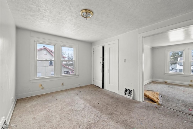 unfurnished bedroom with light carpet and a textured ceiling