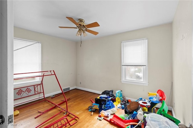 recreation room featuring ceiling fan and hardwood / wood-style floors