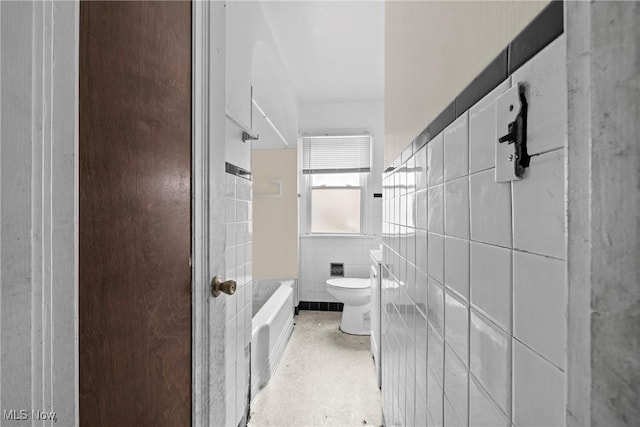 bathroom featuring shower / bathing tub combination, tile walls, and toilet