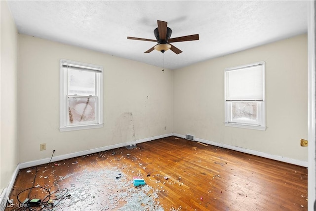 empty room with ceiling fan and hardwood / wood-style floors