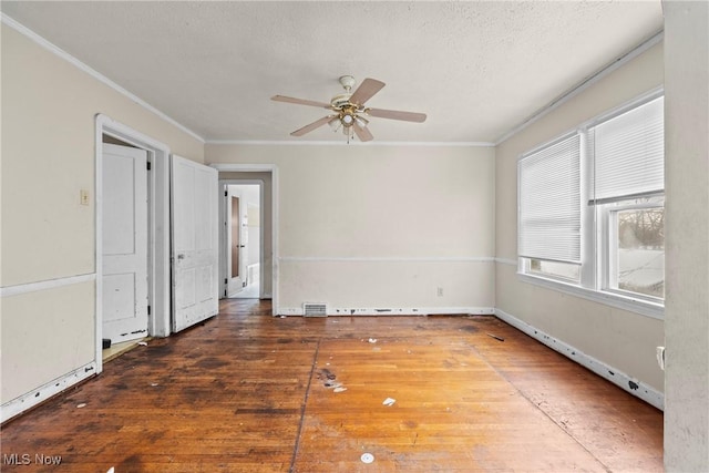 spare room with a textured ceiling, ceiling fan, ornamental molding, and dark hardwood / wood-style floors