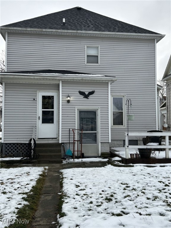 view of snow covered rear of property