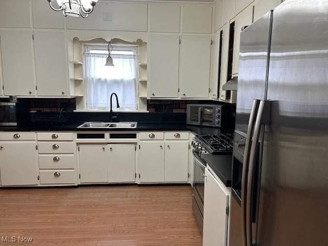 kitchen featuring stainless steel appliances, sink, light hardwood / wood-style flooring, and white cabinets