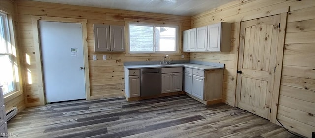 kitchen featuring stainless steel dishwasher, a healthy amount of sunlight, sink, and wood walls