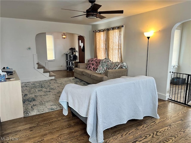 living room featuring ceiling fan and dark hardwood / wood-style floors