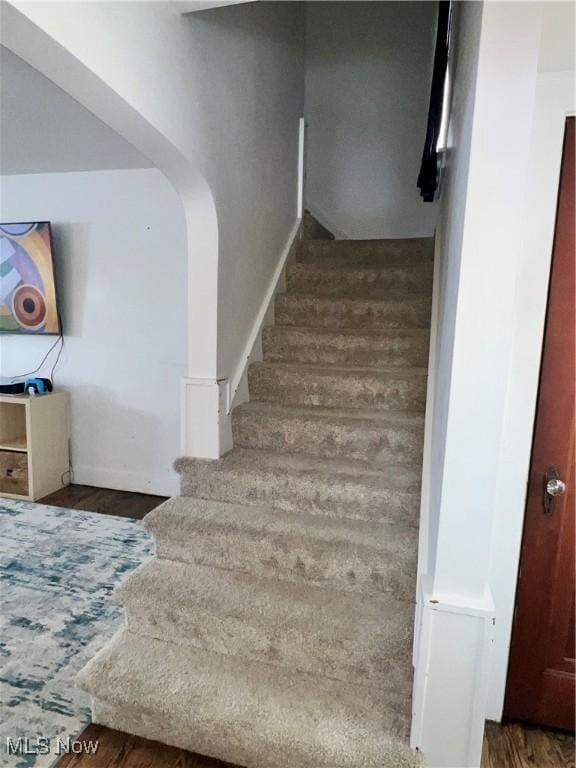 stairs featuring hardwood / wood-style floors