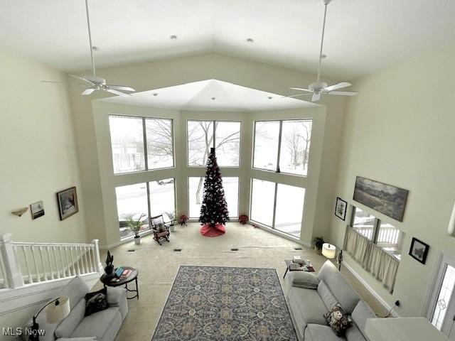 living room with a high ceiling, plenty of natural light, and ceiling fan