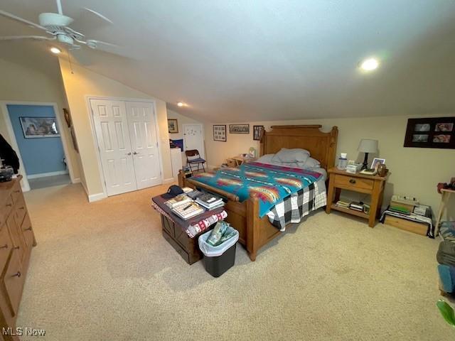 carpeted bedroom with vaulted ceiling, a closet, and ceiling fan