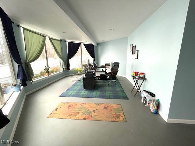 dining space with lofted ceiling and concrete floors