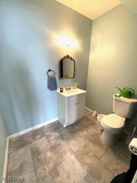 7716 N Ridge Pl, Lisbon, OH 44432 - half bathroom featuring baseboards, toilet, and vanity