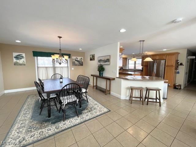 tiled dining room featuring an inviting chandelier